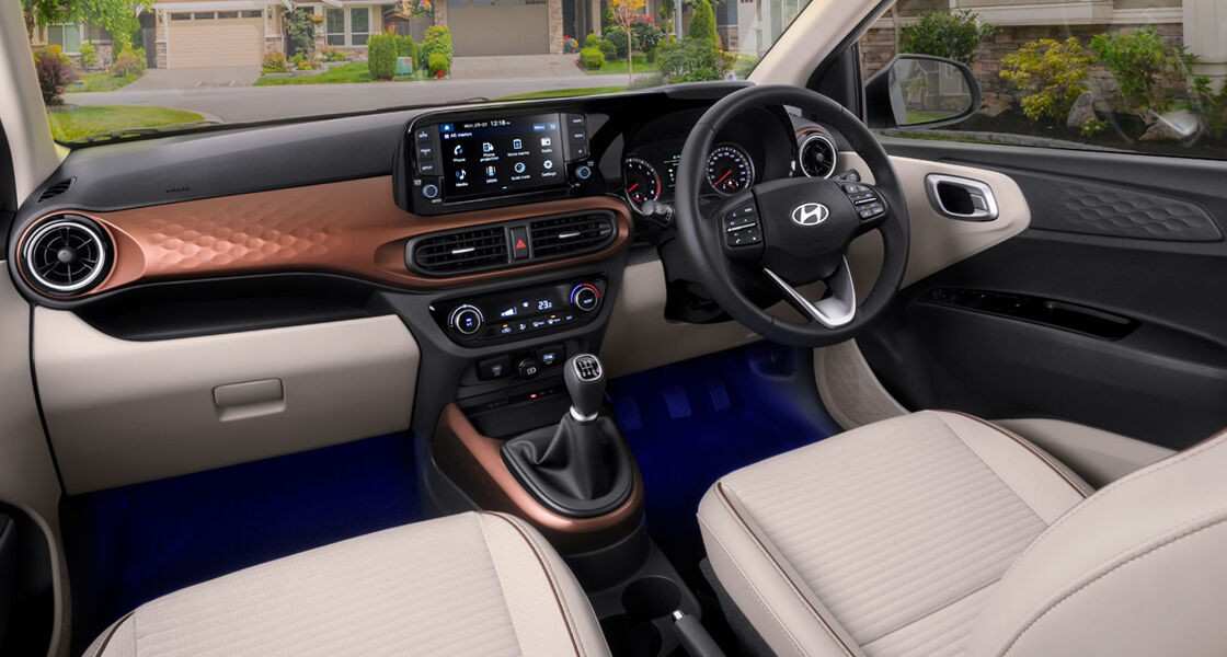 Hyundai AURA 2025 interior with dual-tone dashboard, touchscreen infotainment and premium beige seats