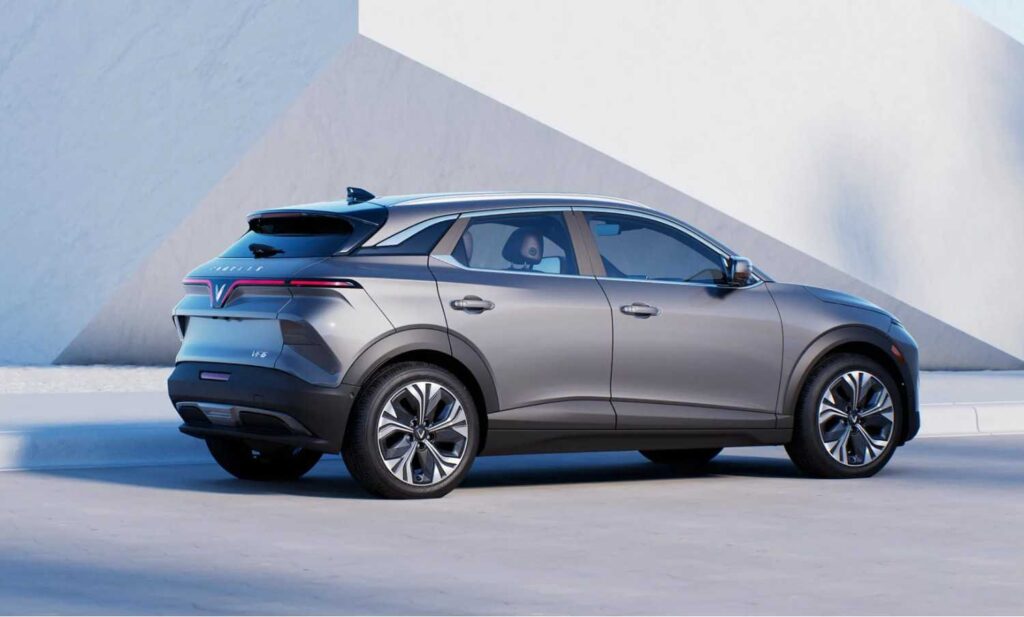 VinFast VF 6 2025 – Futuristic silver electric SUV with aerodynamic design, premium alloy wheels, and bold rear styling parked beside modern architecture