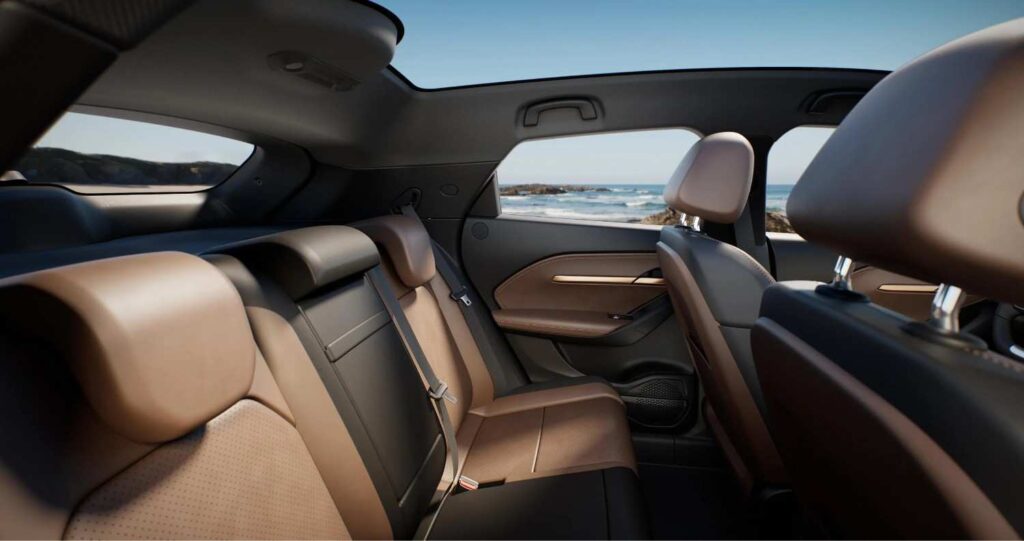 Luxurious brown leather rear seats of an SUV with panoramic side windows and a scenic ocean view